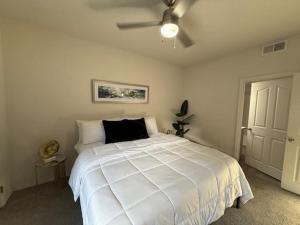 a bedroom with a white bed with a ceiling fan at Zen Oasis in Phoenix +15 photos