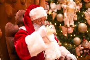a man dressed as santa claus drinking a cup of coffee at Chocoland Hotel Gramado in Gramado