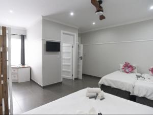 a white room with two beds and a tv at Heidelberg Crown Hotel in Heidelberg
