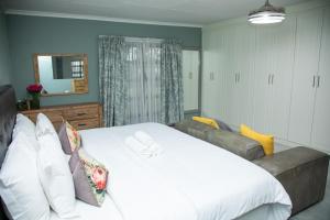 a bedroom with a large white bed and a couch at Origon Farmhouse in Brits +42 photos