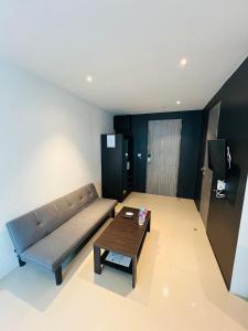 ein Wohnzimmer mit einer Couch und einem Couchtisch in der Unterkunft Utopia Kathu Condo in Phuket