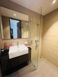 ein Badezimmer mit Waschbecken und Dusche in der Unterkunft Utopia Kathu Condo in Phuket