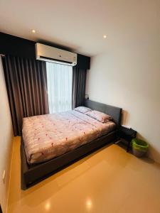 ein kleines Schlafzimmer mit einem Bett mit Fenster in der Unterkunft Utopia Kathu Condo in Phuket