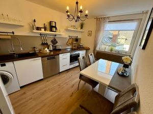 a kitchen with a table and a dining room at Schwebebahn View Apartment in Wuppertal