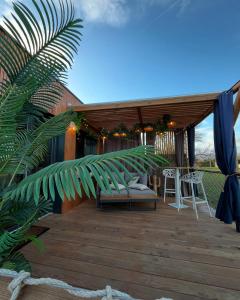 a wooden deck with a bench and a chair on it at Glamour tinyhouse in Muret