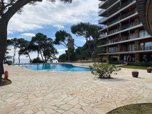 a swimming pool next to a large apartment building at Eden Mar Sant Antoni de Calonge in Sant Antoni de Calonge