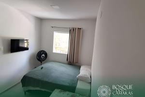 a small bedroom with a bed and a window at Refuge Aldeia dos Camarás in Camaragibe