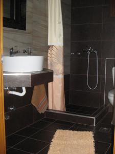 a bathroom with a sink and a shower at ΠΑΝΣΙΟΝ ΑΓΓΕΛΟΣ ΜΑΝΑΡΗ in Ouranoupoli