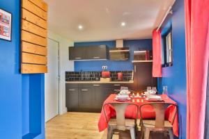 a dining room with a table and a kitchen at Chalet Cinema Les Belles Ouvrières in Clermont-Créans