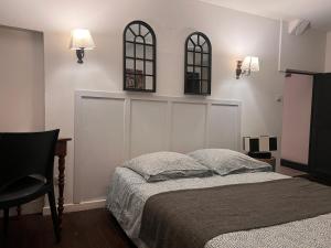 een slaapkamer met een bed en twee spiegels aan de muur bij 4 - Les pins roses in Poitiers