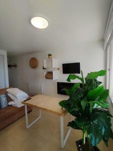 Una sala de estar con una mesa y una planta. en MIRAMAR con vistas, en Sierra Nevada