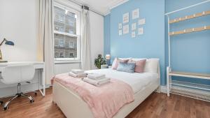 a bedroom with blue walls and a bed with a desk at Bloomsbury Homes in London