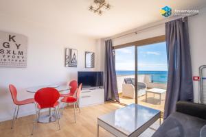 un soggiorno con tavolo, sedie e vista sull'oceano di Apto Antic 302 Pax 4 a S'Illot