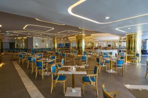 ein Esszimmer mit Tischen und blauen Stühlen in der Unterkunft Super 2Bdr Apartament La Vita Rawai Naiharn beach in Rawai Beach