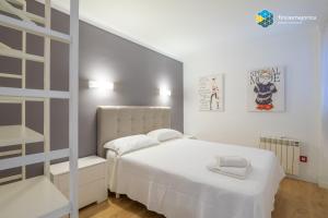 una camera bianca con un letto bianco e una scala di Apto Antic 302 Pax 4 a S'Illot