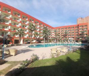 a large building with a swimming pool in front of it at Grand Pyramids Hotel in Cairo