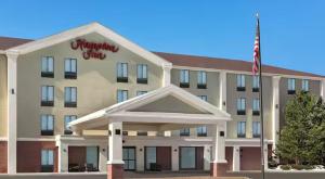 un hotel con una bandera americana delante de él en Hampton Inn & Suites By Hilton Wheat Ridge Denver West, en Wheat Ridge