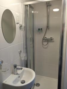 a bathroom with a shower and a sink and a mirror at Maon Hotel in Brighton & Hove
