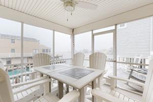 a white dining room with a table and chairs on a balcony at West Fenwick --- 39110 Van Buren Ave in Selbyville