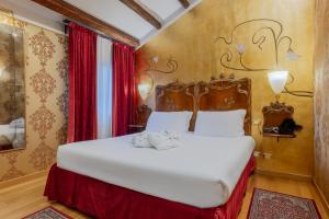 a bedroom with a large white bed with red curtains at Ca Dell'Arte in Venice +122 photos