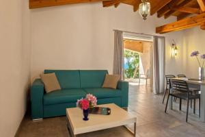 a living room with a blue couch and a table at Charmante Maison de Vacances à Olmeto avec Piscine in Olmeto
