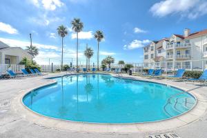 una grande piscina con sedie e palme di Island Getaway a Padre Island