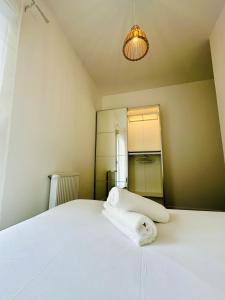 a bedroom with a white bed with a towel on it at Horizon House - Roissy CDG - Parc des Expos in Villepinte