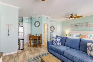 un soggiorno con un divano blu e un letto di Island Getaway a Padre Island