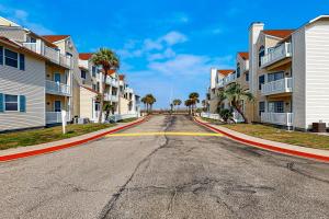 una strada vuota in un complesso di appartamenti con palme di Island Getaway a Padre Island
