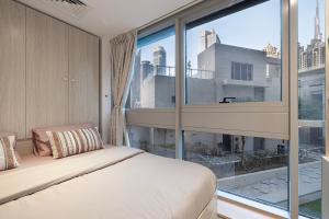 迪拜Next'Living - Luxury Private Room in a CoLiving Villa的一间带床和大窗户的卧室