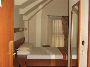 a small bedroom with a bed and a window at Hotel Transit in Oradea