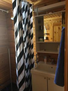 a bathroom with a black and white shower curtain at Eco-Villa Saturnus in Simo