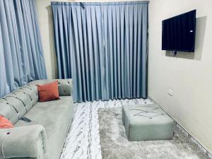 a living room with a couch and a flat screen tv at Truzt Inn Cozy Ensuite Rooms in Kumasi