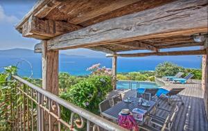 una terrazza con tavolo, sedie e vista sull'oceano di Villa moderne avec piscine privée à Olmeto - 95 m² a Olmeto