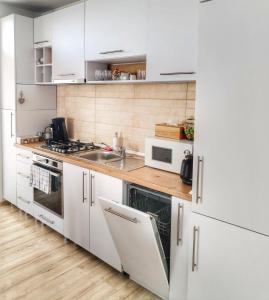 a white kitchen with a sink and a microwave at Carolina in Alba Iulia