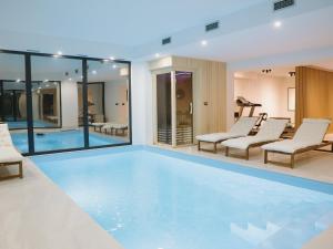 a swimming pool with lounge chairs and a swimming pool at Woodlander Mountain House Blidinje in Blidinje