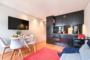 a living room with a table and a kitchen at Abrigo Muralha By Sé Apartamentos in Braga +5 photos
