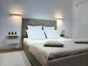 una camera da letto con un letto grande con cuscini bianchi di Inga Oasis a Turda