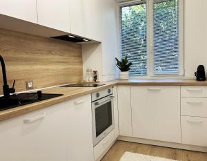 a kitchen with white cabinets and a sink at Inga Oasis in Turda