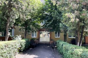 una casa gialla con una porta bianca e alberi di Inga Oasis a Turda