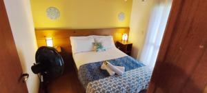 プライア・ド・ローザにあるCasa Dos Ventos Hospedagem Praia do Rosaのベッドとタオル2枚のある寝室