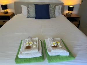 a bed with two baskets with towels and flowers on it at Villalina : Cosy, piscine privée, proche Grand Baie et plages in Pereybere +44 photos
