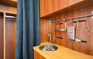 a kitchen with a sink and a blue curtain at Giù in centro in Putignano