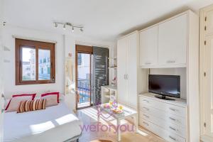 a living room with a bed and a tv at weforyou Old Town Benalmadena in Benalmádena