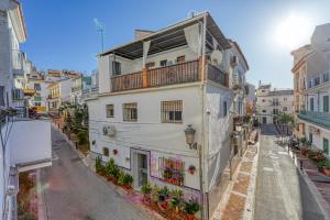 a white building with a balcony on a street at weforyou Old Town Benalmadena in Benalmádena