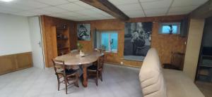 a dining room with a wooden table and chairs at Maison chez l'habitant in Bouère
