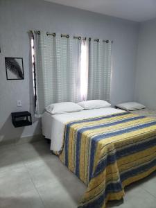 a bedroom with a bed with a blanket on it at Rio Quente - Pousada do Charme in Rio Quente