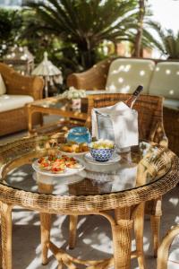 a wicker table with plates of food on it at Relais Valle Dell'Idro - Rooftop & Sea View, Otranto in Otranto