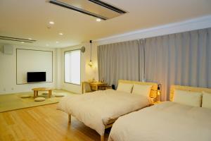 a hotel room with two beds and a television at wanderlust STAY in Kofu