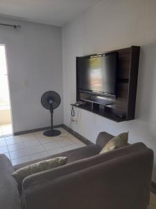 a living room with a couch and a flat screen tv at Rio Quente Thermas Paradise in Rio Quente